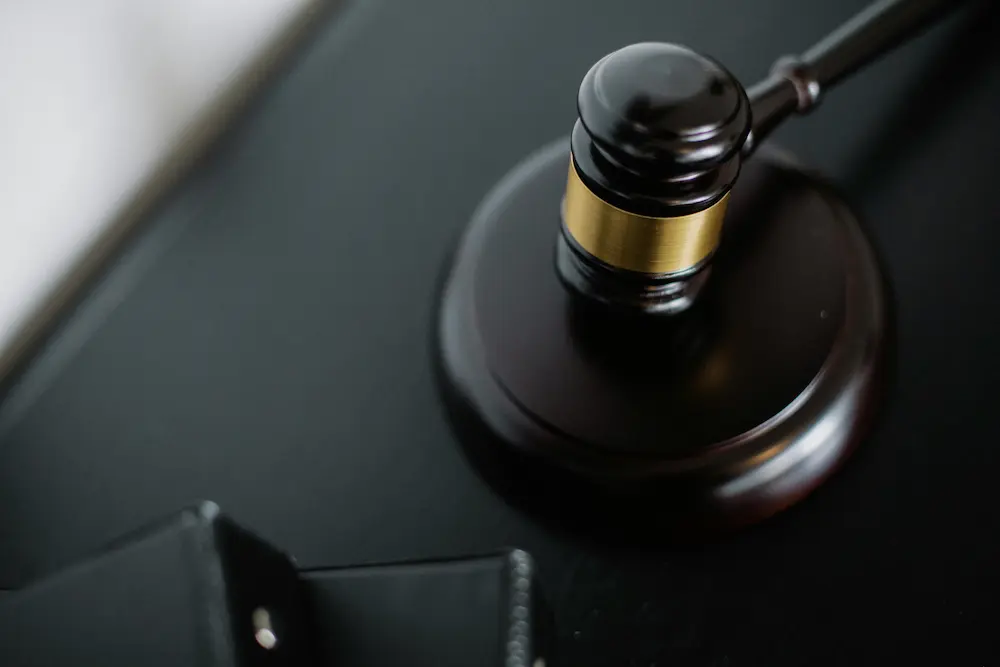 Mazo judicial sobre escritorio, representando decisiones judiciales y obligaciones tributarias en pagos judiciales en Colombia.