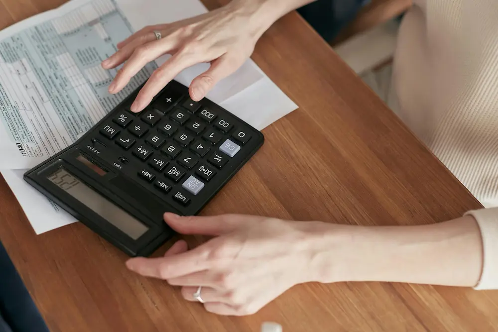 ersona revisando documentos contables y usando calculadora para analizar saldo a favor de IVA, compensación e imputación según Concepto DIAN y artículos 481, 477, 468-1 del Estatuto Tributario, contexto empresas Colombia.