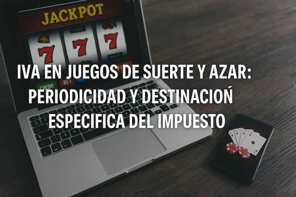 Laptop con tragamonedas online y celular con cartas de póker sobre mesa de madera, ilustrando el IVA en juegos de suerte y azar operados por internet según el Concepto DIAN No. 100208192-426 de 2025.